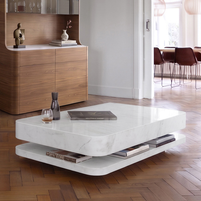 Table basse en marbre blanc sur un parquet en chevrons, devant un buffet en noyer