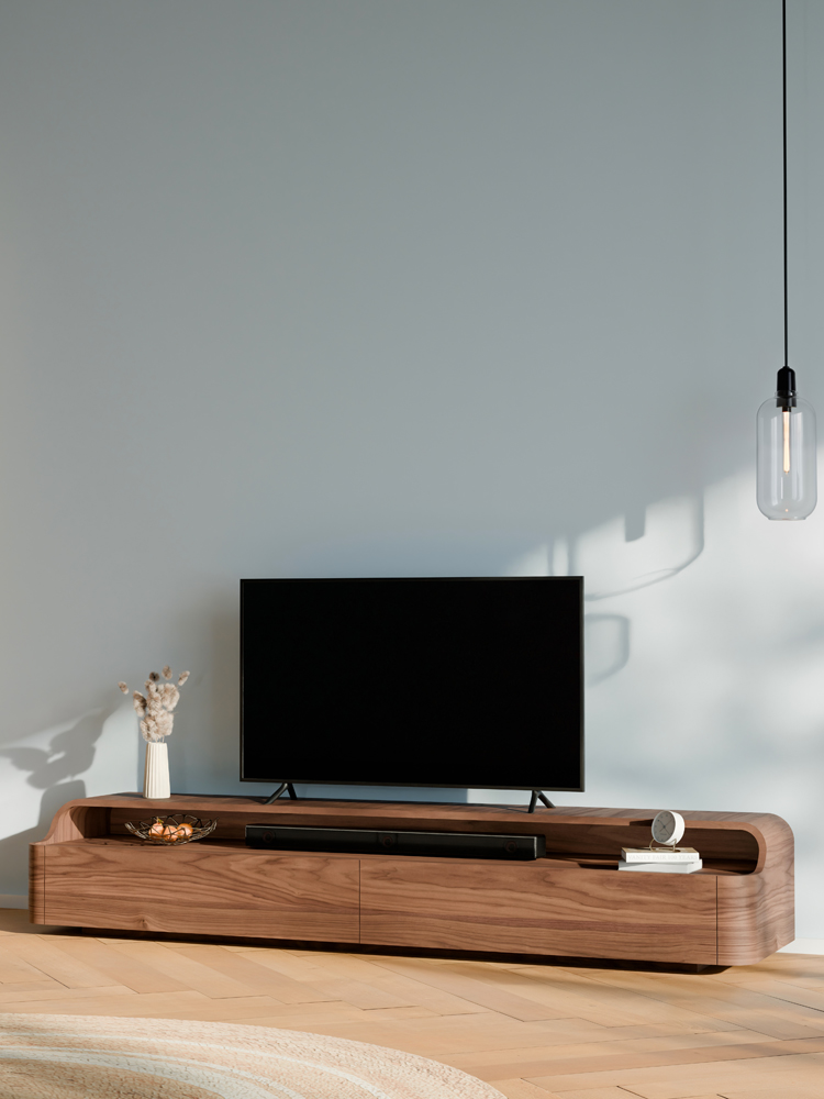 RKNL TV-meubel Embrace in notenfineer – zijaanzicht toont de elegante golfbeweging tussen TV-plateau en soundbar vak